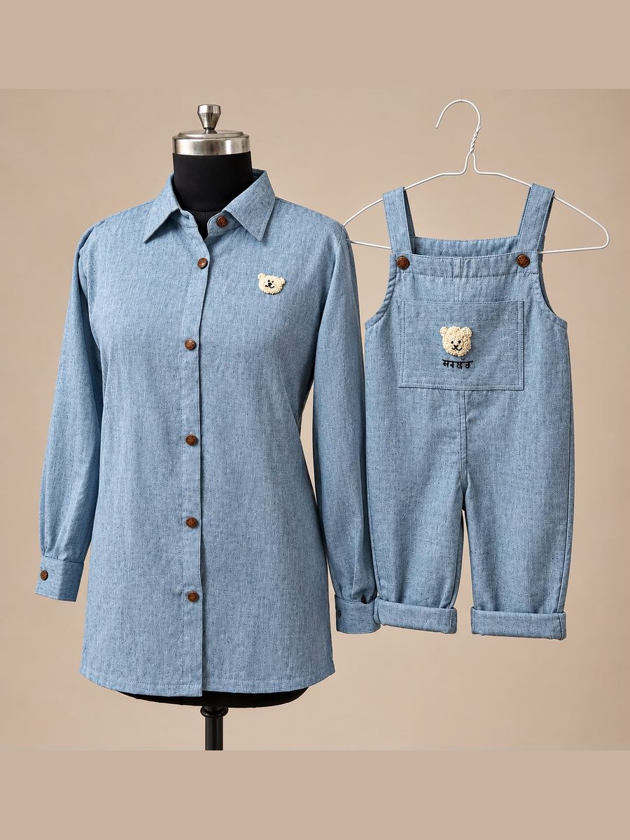 A woman's chambray shirt beside a child's chambray dungarees, both with an embroidered teddy